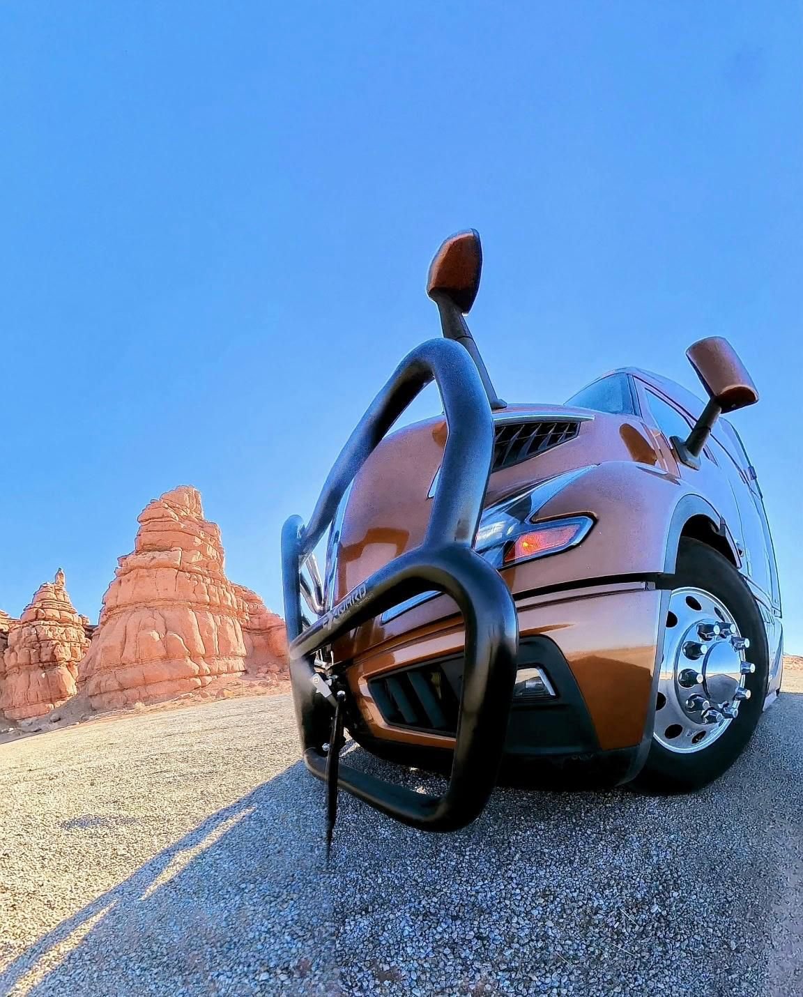 Low-angle view of a Barcelona Express tractor grille with red rock formations in the background