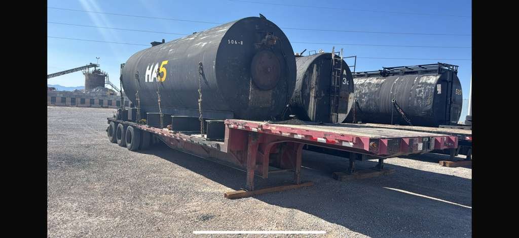 Flatbed trailer hauling a large industrial tank